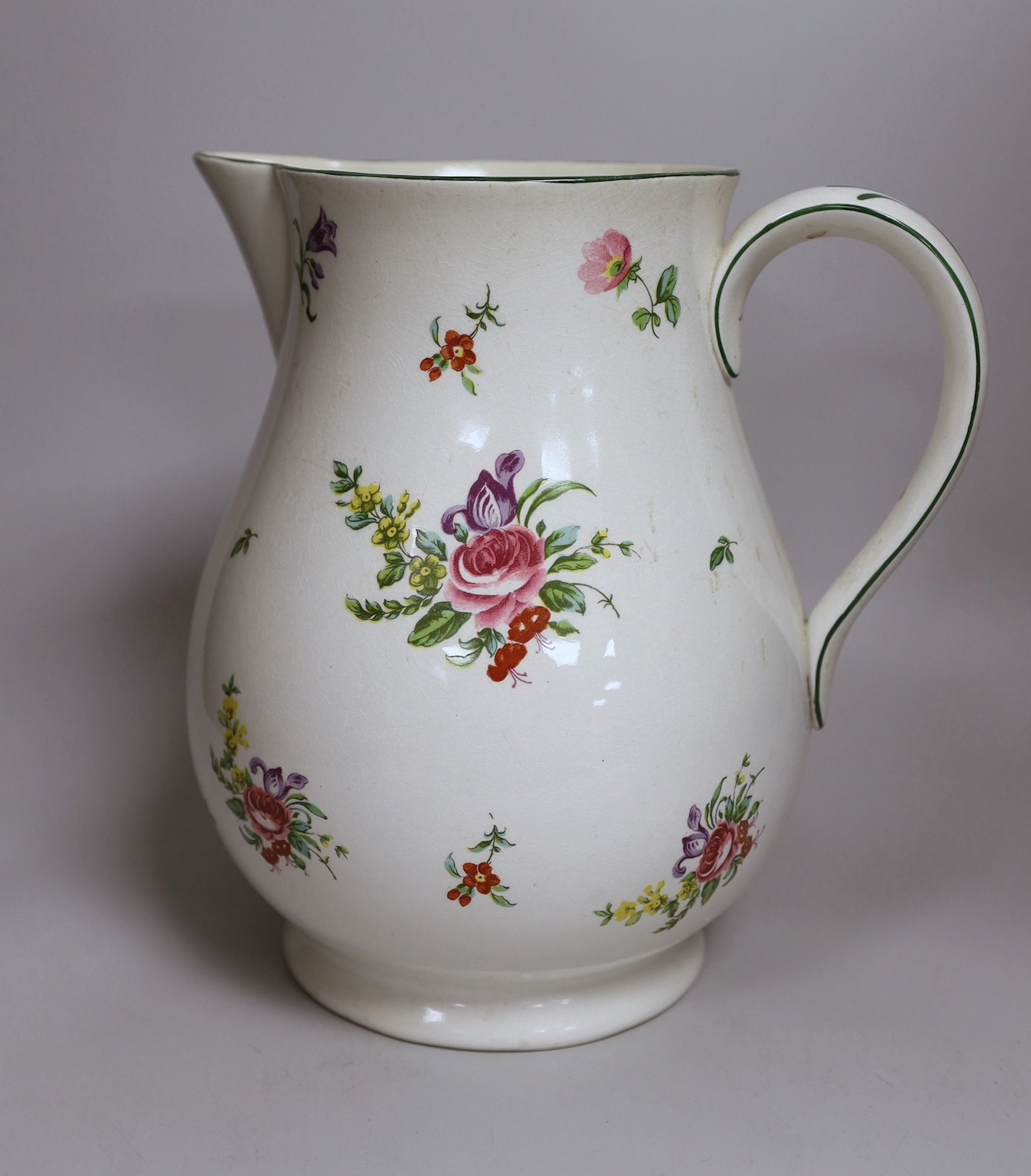 A Pountney jug, commemorating 100 years of the Bristol porcelain factory 1770 -1781, decorated with floral sprays and sprigs, green line border, 27cm high, printed mark. 26.5cm